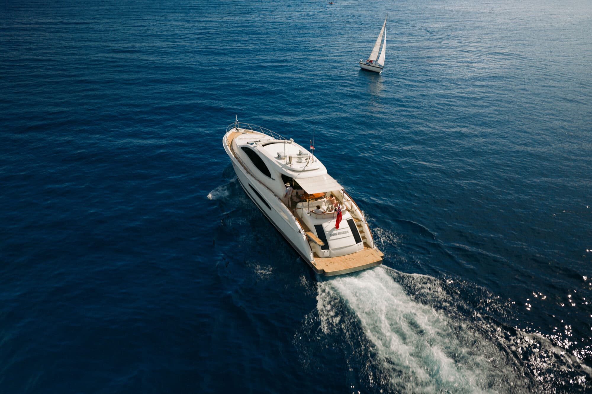 Sans Regret under way off the Côte d’Azur, seen from above with the coastline behind